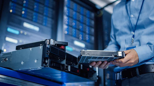 IT technician holding a server hard drive in a data centre